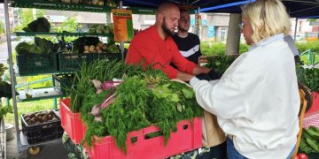 Kobieta kupująca warzywa od lokalnego rolnika