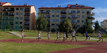 Grupa dzieci wykonująca ćwiczenia lekkoatletyczne